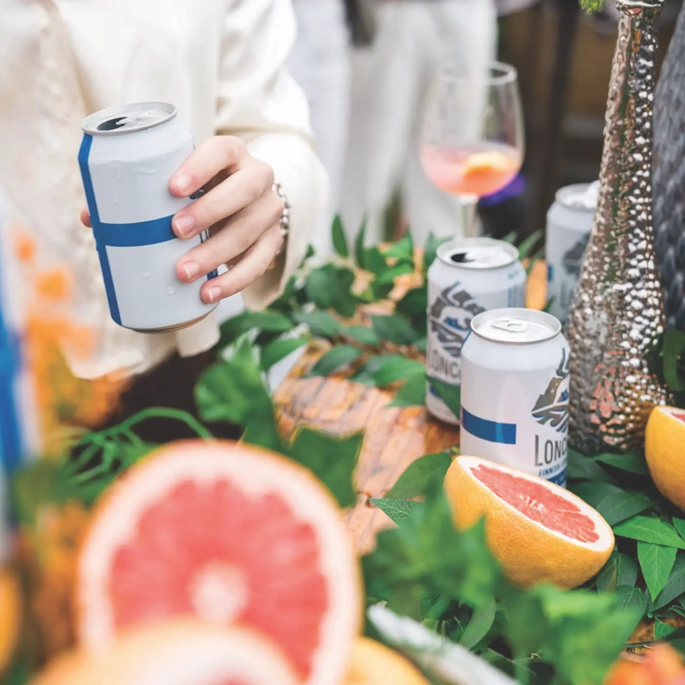 Cans of Loncaro on a wooden table surrounded by sliced grapefruit