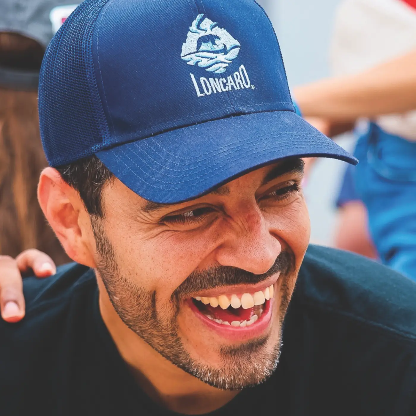 Man wearing a blue Loncaro baseball cap